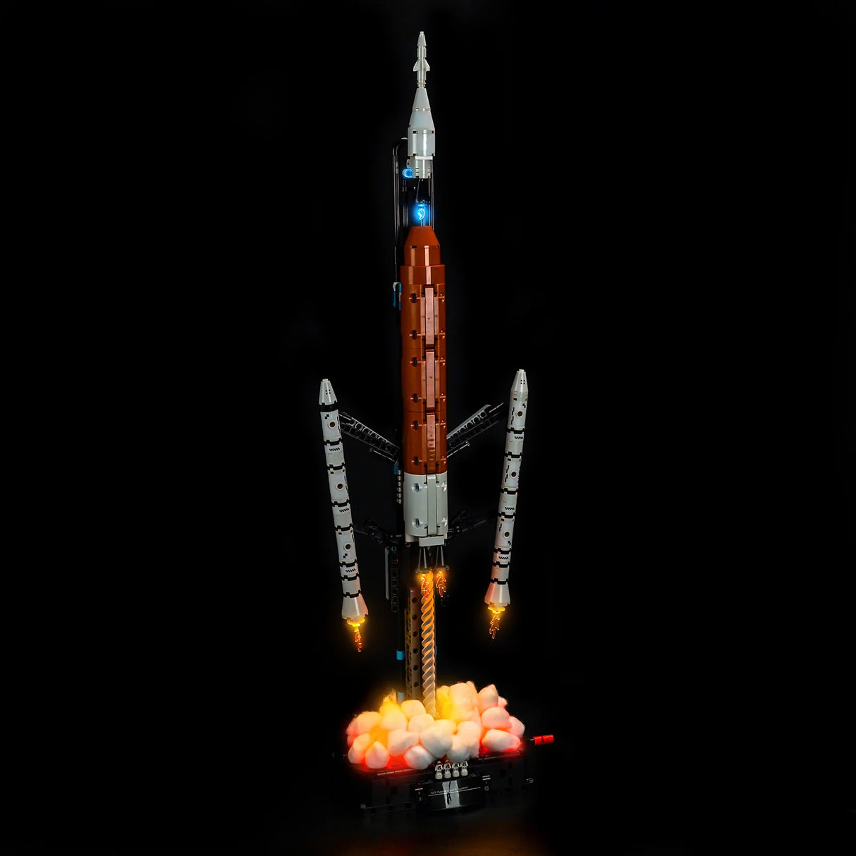 Raketenmodell mit leuchtenden Triebwerken und Rauch auf schwarzem Hintergrund