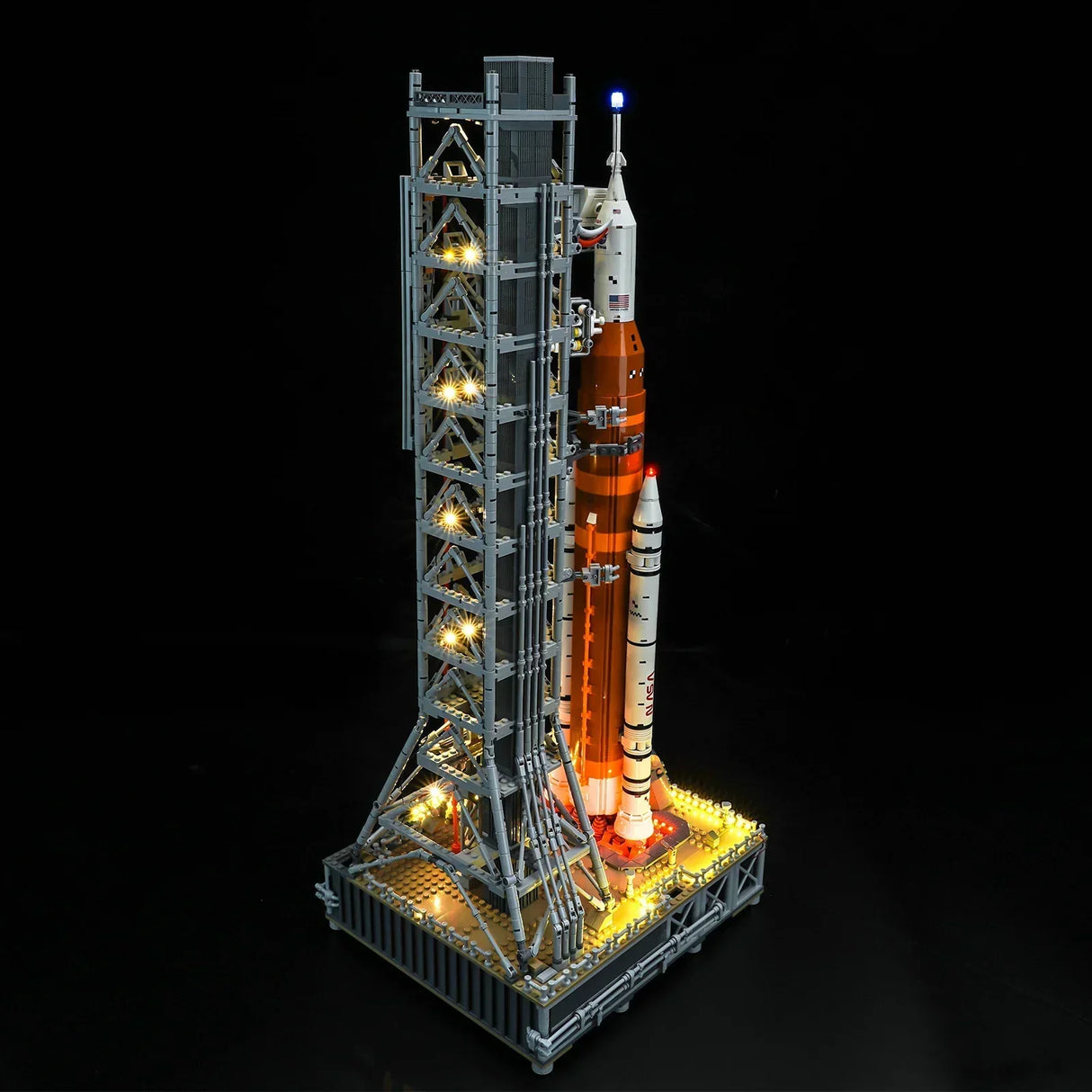 Beleuchtetes Lego Modell einer NASA Rakete mit Startturm vor schwarzem Hintergrund