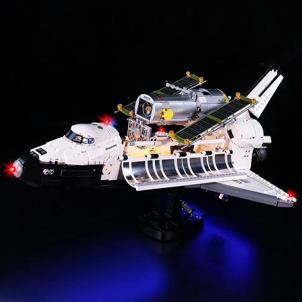 Beleuchtetes Lego Modell der Discovery Raumfähre mit Hubble Weltraumteleskop vor schwarzem Hintergrund