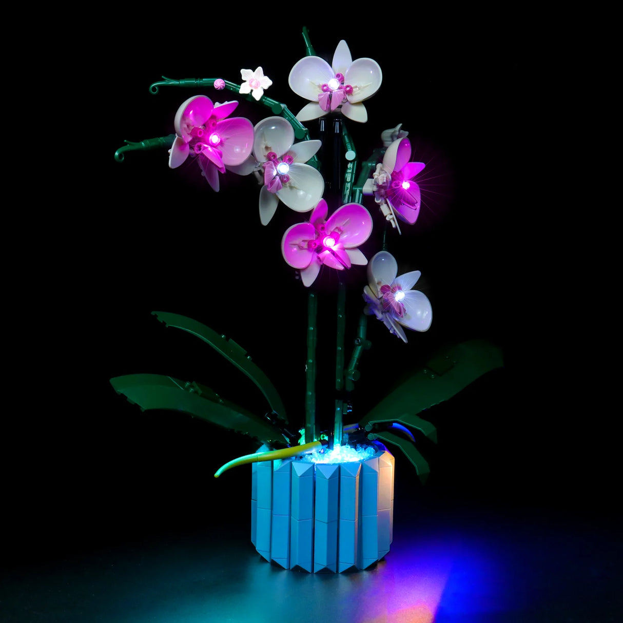 Lego Orchidee Modell mit integrierter LED Beleuchtung in einem blauen Topf vor schwarzem Hintergrund