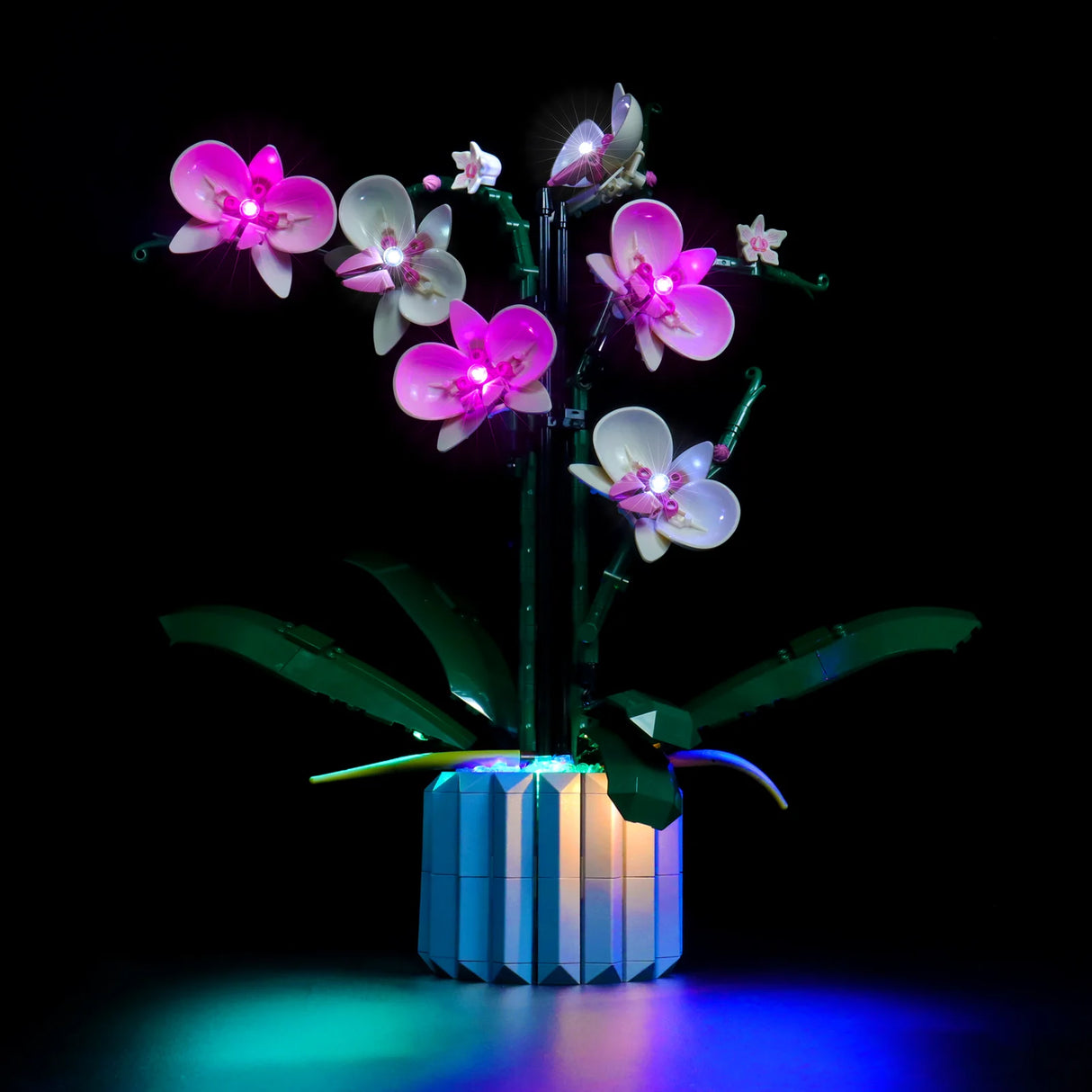 Beleuchtete Lego Orchidee in einem Topf vor schwarzem Hintergrund