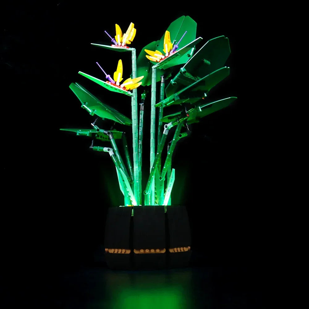 Beleuchtete Lego Paradiesvogelblume in einem schwarzen Topf vor schwarzem Hintergrund