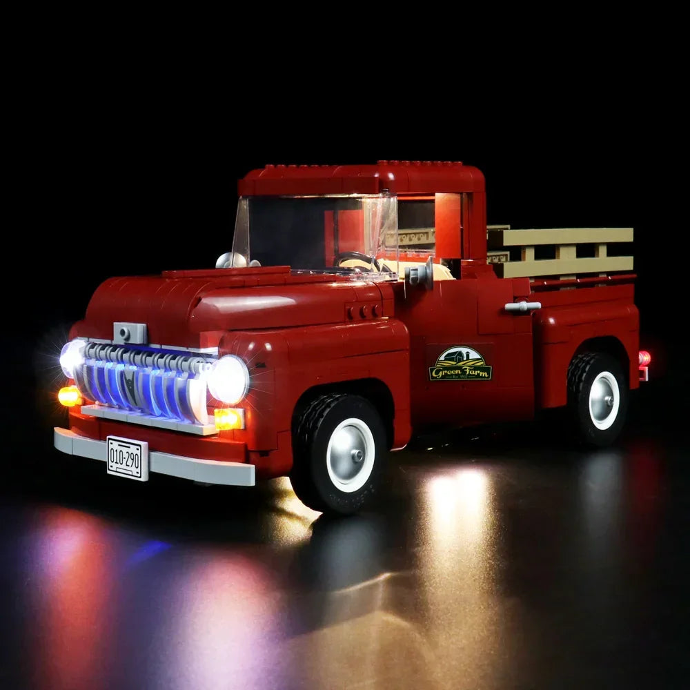 Roter Lego Pickup Truck mit eingeschalteter LED Beleuchtung vor schwarzem Hintergrund