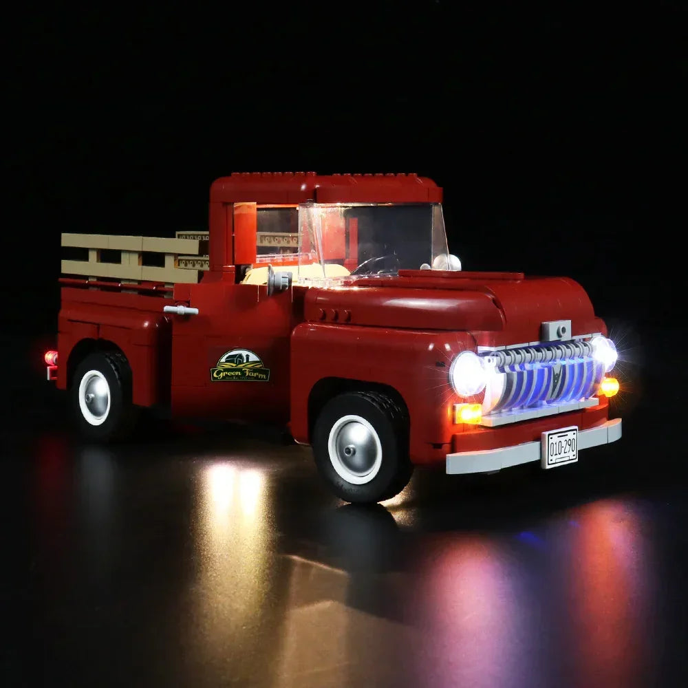Roter Lego Pickup Truck mit eingeschalteter Beleuchtung vor schwarzem Hintergrund