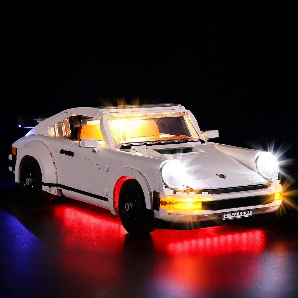 Weißes Lego Porsche Modellauto mit eingeschalteter LED Beleuchtung vor schwarzem Hintergrund