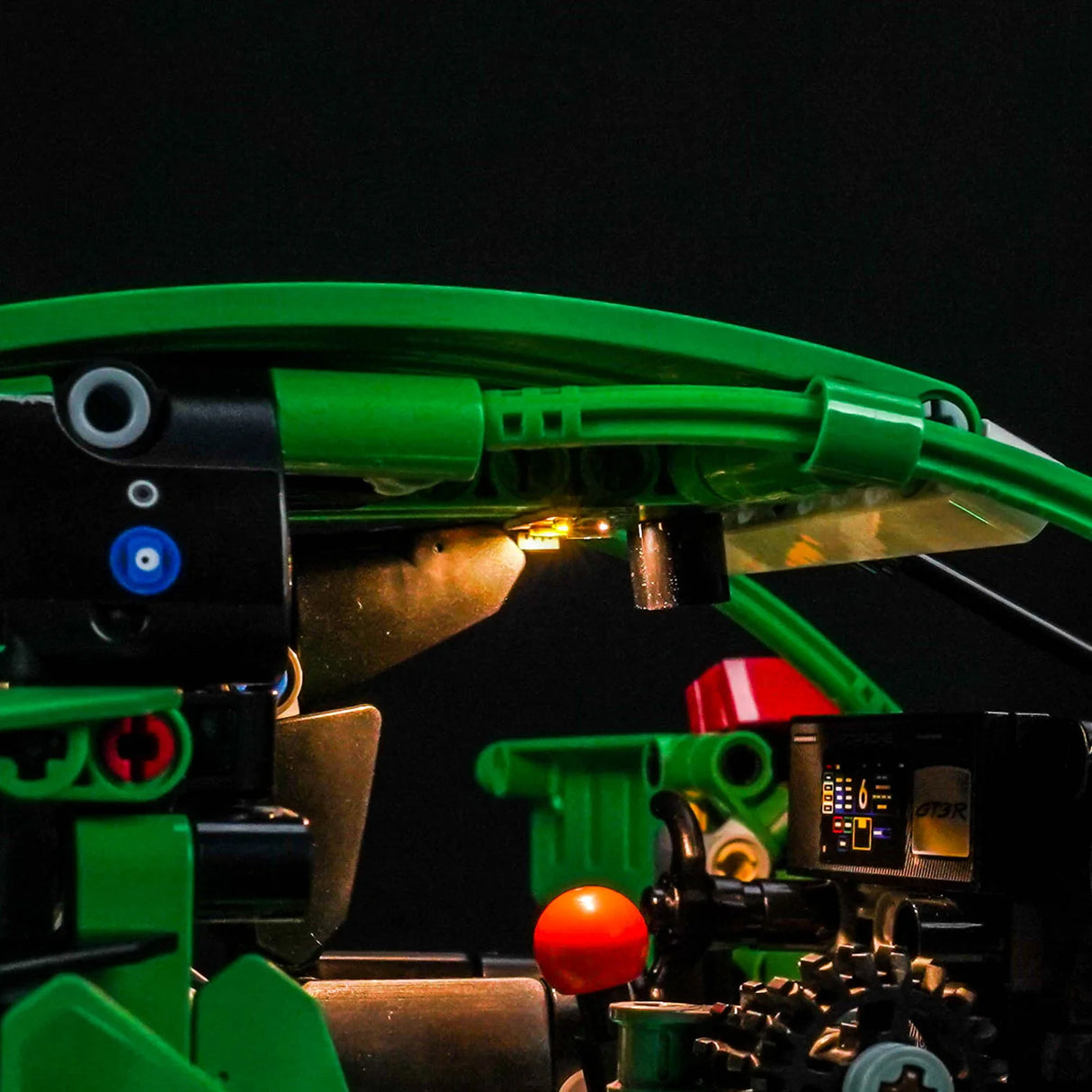 Nahaufnahme eines grünen Lego-Modells mit leuchtenden Lichtern und einem Display