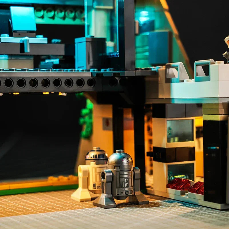 Zwei kleine Roboterfiguren vor einer beleuchteten Lego Star Wars Basis