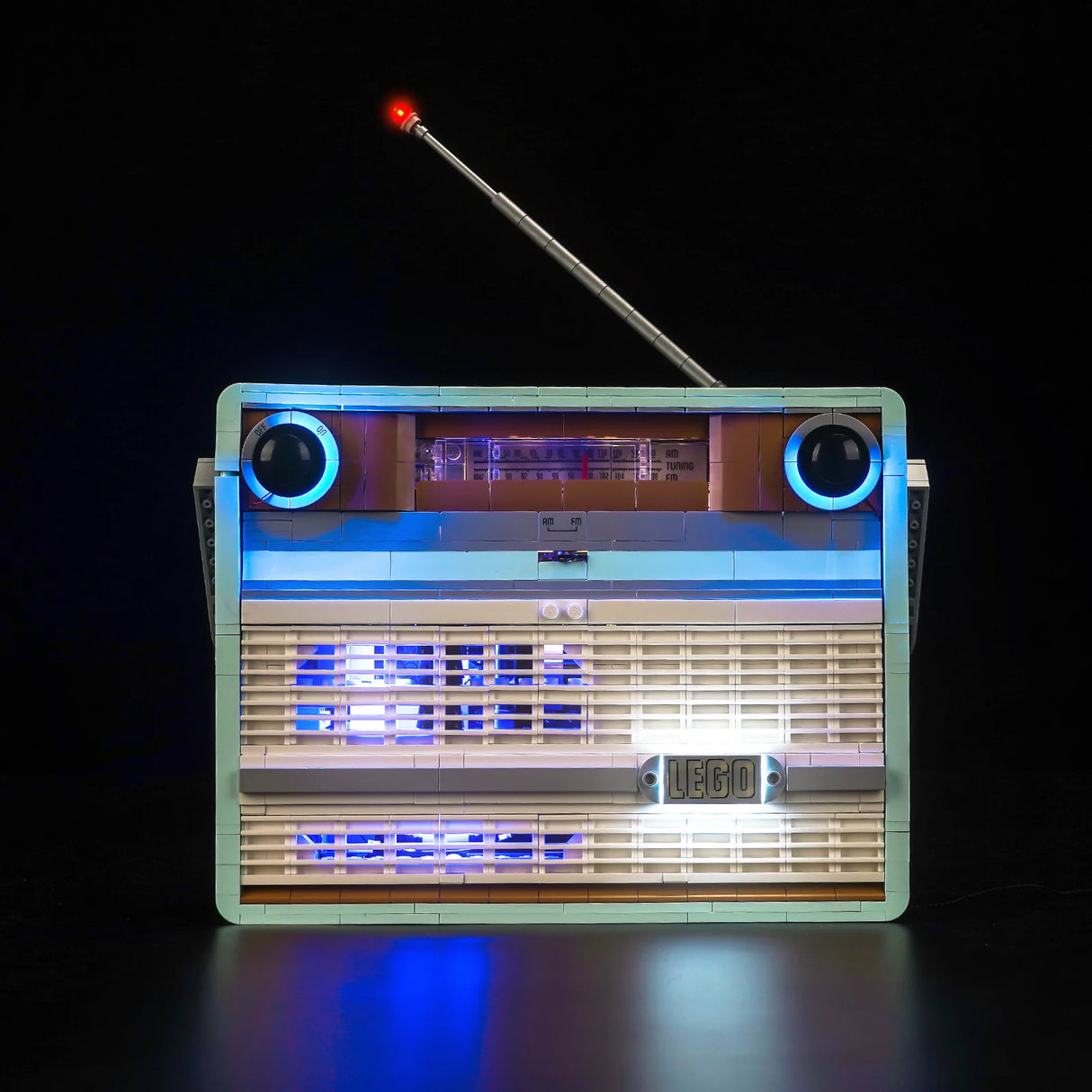 Beleuchtetes Radio aus Bausteinen mit ausgefahrener Antenne vor schwarzem Hintergrund