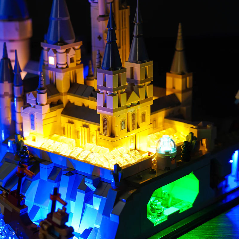 Beleuchtetes Lego Schlossmodell mit gelben Fenstern und blauem Untergrund