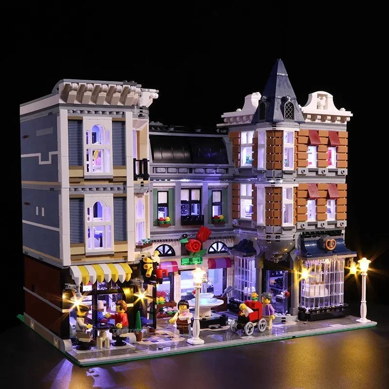 Beleuchtetes Lego Gebaeude mit Ladenfronten und Minifiguren vor schwarzem Hintergrund