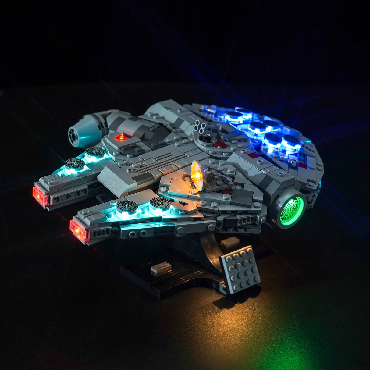 Beleuchtetes Lego Modell des Millennium Falken vor schwarzem Hintergrund
