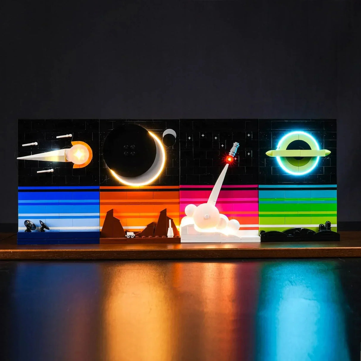Vier beleuchtete Lego Weltraum Szenen mit Planeten Raketenstart und Satelliten vor schwarzem Hintergrund