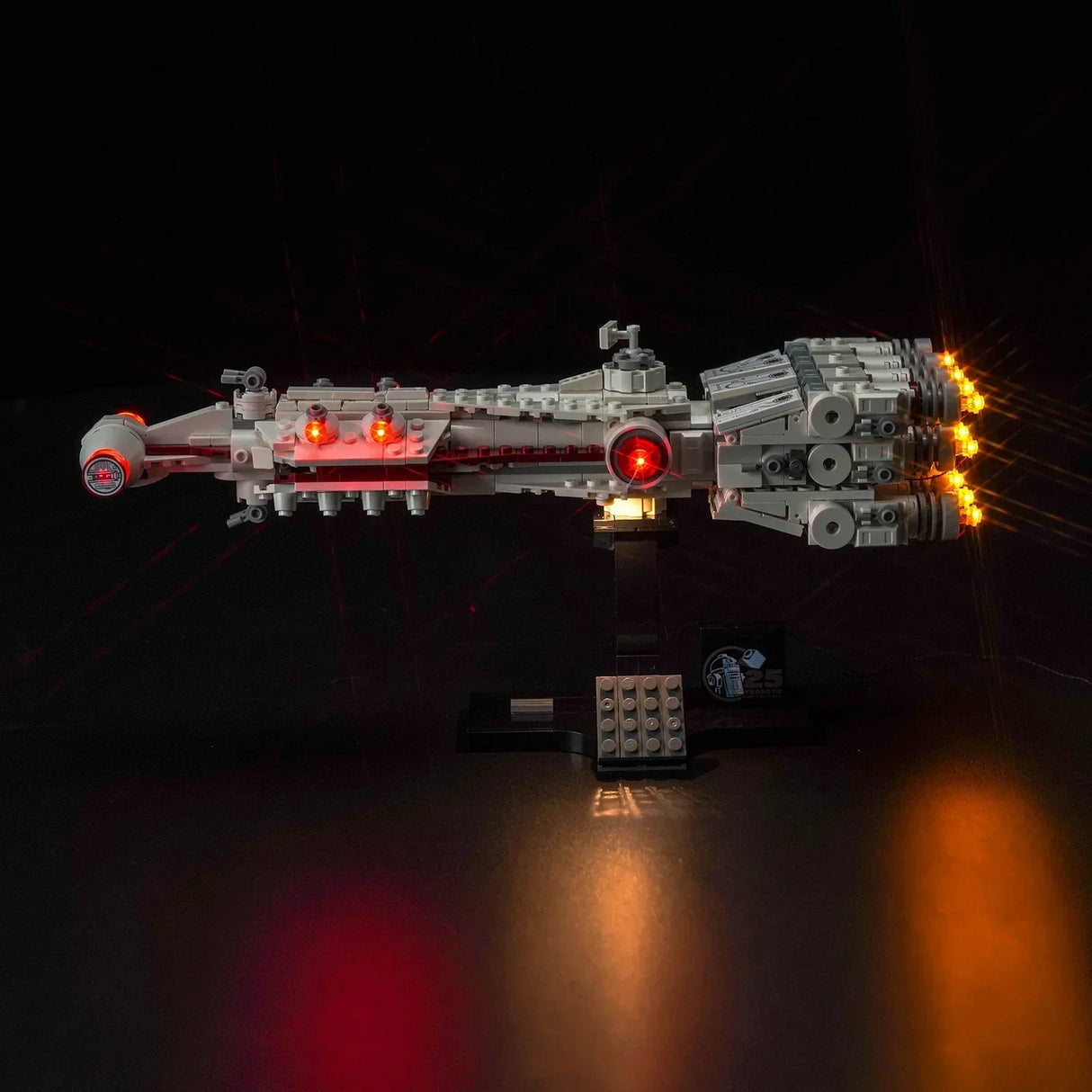 Beleuchtetes Lego Modell der Tantive IV auf einem schwarzen Ständer vor dunklem Hintergrund