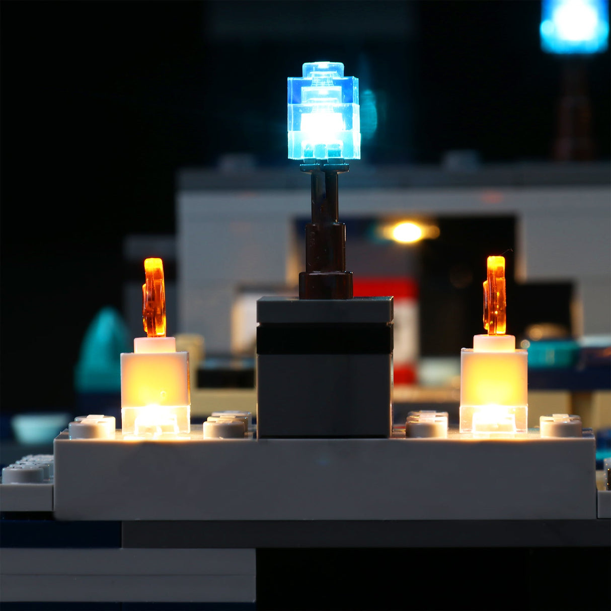 Beleuchtetes Lego Modell mit einer blauen LED in der Mitte und zwei orangefarbenen Lichtern an den Seiten