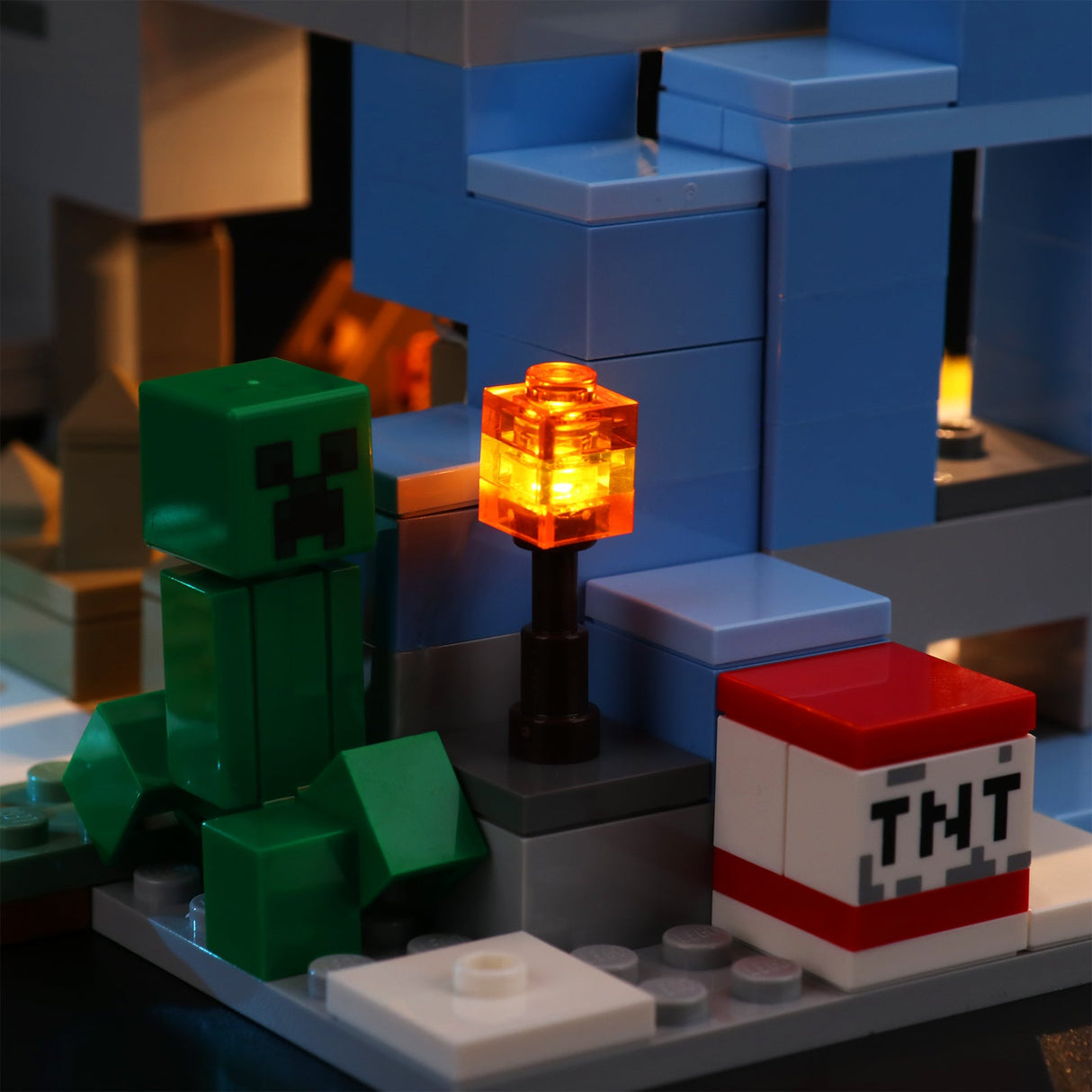 Minecraft Lego Figur Creeper neben einer leuchtenden Fackel und einem TNT Block