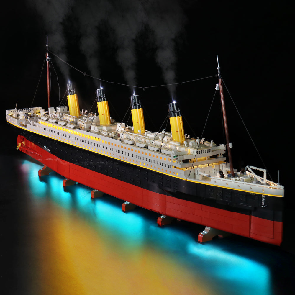 Komplettansicht der LEGO Titanic 10294 von der Steuerbordseite mit eingeschalteter LED-Beleuchtung, rauchenden Schornsteinen und blauer Unterwasserbeleuchtung.