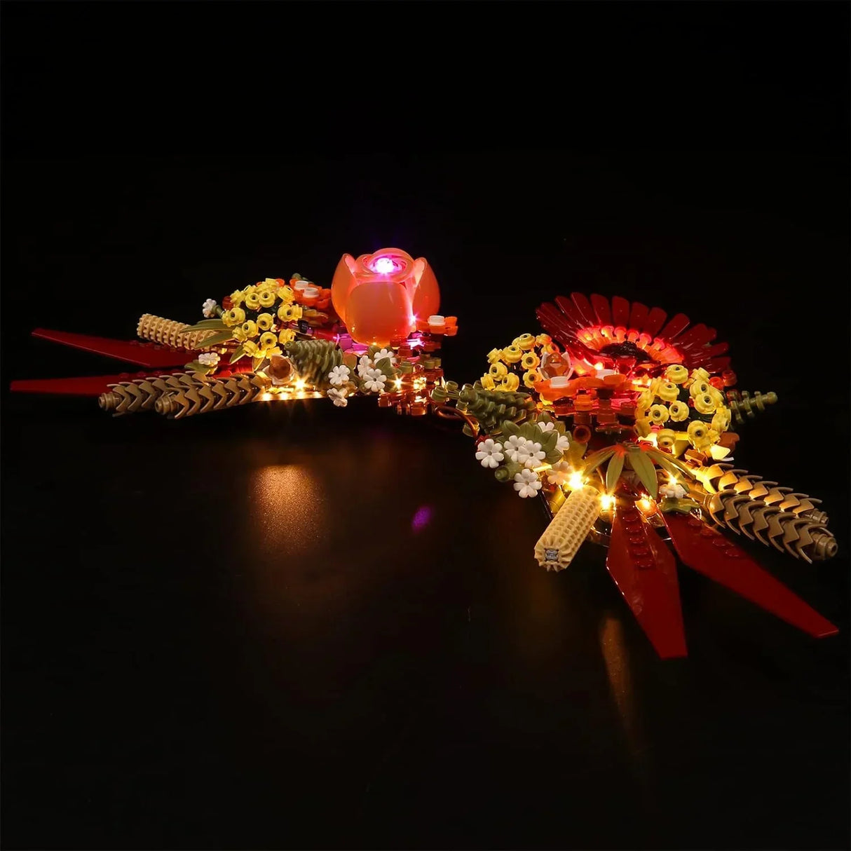 Das fertig aufgebaute LEGO Icons Trockenblumengesteck 10314 auf schwarzem Hintergrund, stimmungsvoll illuminiert durch ein LED-Beleuchtungsset.