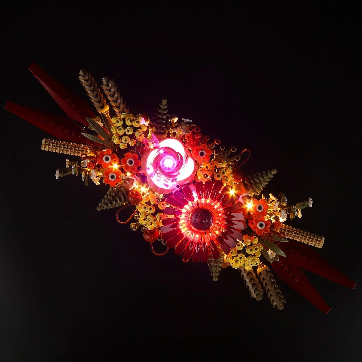 Komplette Vogelperspektive des LEGO 10314 Trockenblumengestecks mit leuchtenden LED-Dioden in warmweiß und pink vor dunklem Hintergrund.