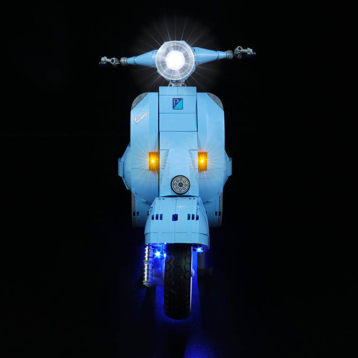 Hellblaues Vespa Modell aus Klemmbausteinen mit eingeschalteter LED Beleuchtung vor schwarzem Hintergrund