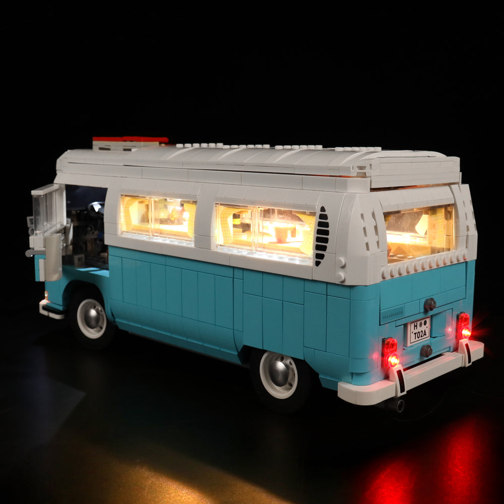 Beleuchtetes Lego Modell eines blau weissen VW Busses vor schwarzem Hintergrund