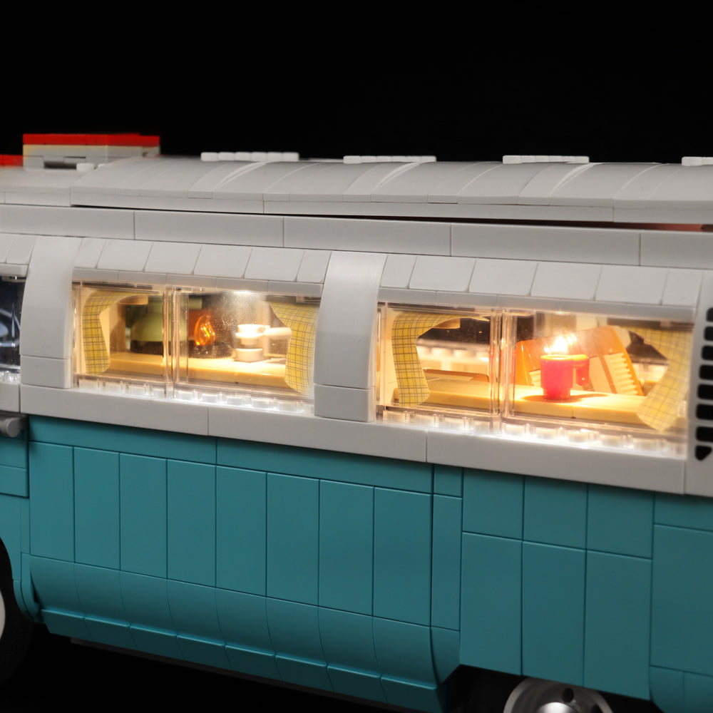Beleuchtetes Interieur eines blauen Lego Wohnmobils mit Vorhängen und Tischen