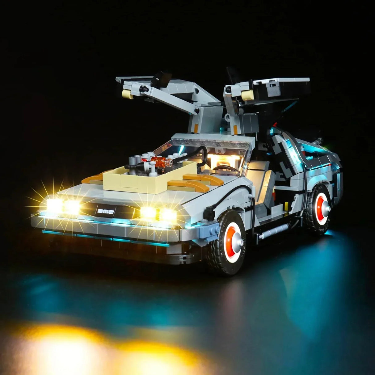 Beleuchtetes Lego Modell des DeLorean Zeitmaschinenautos mit geöffneten Flügeltüren vor schwarzem Hintergrund