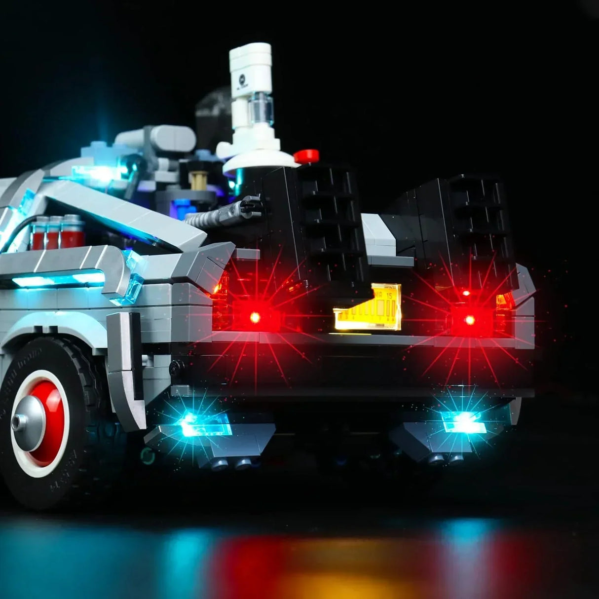 Lego Modell des DeLorean mit leuchtenden roten und blauen LED Lichtern vor schwarzem Hintergrund