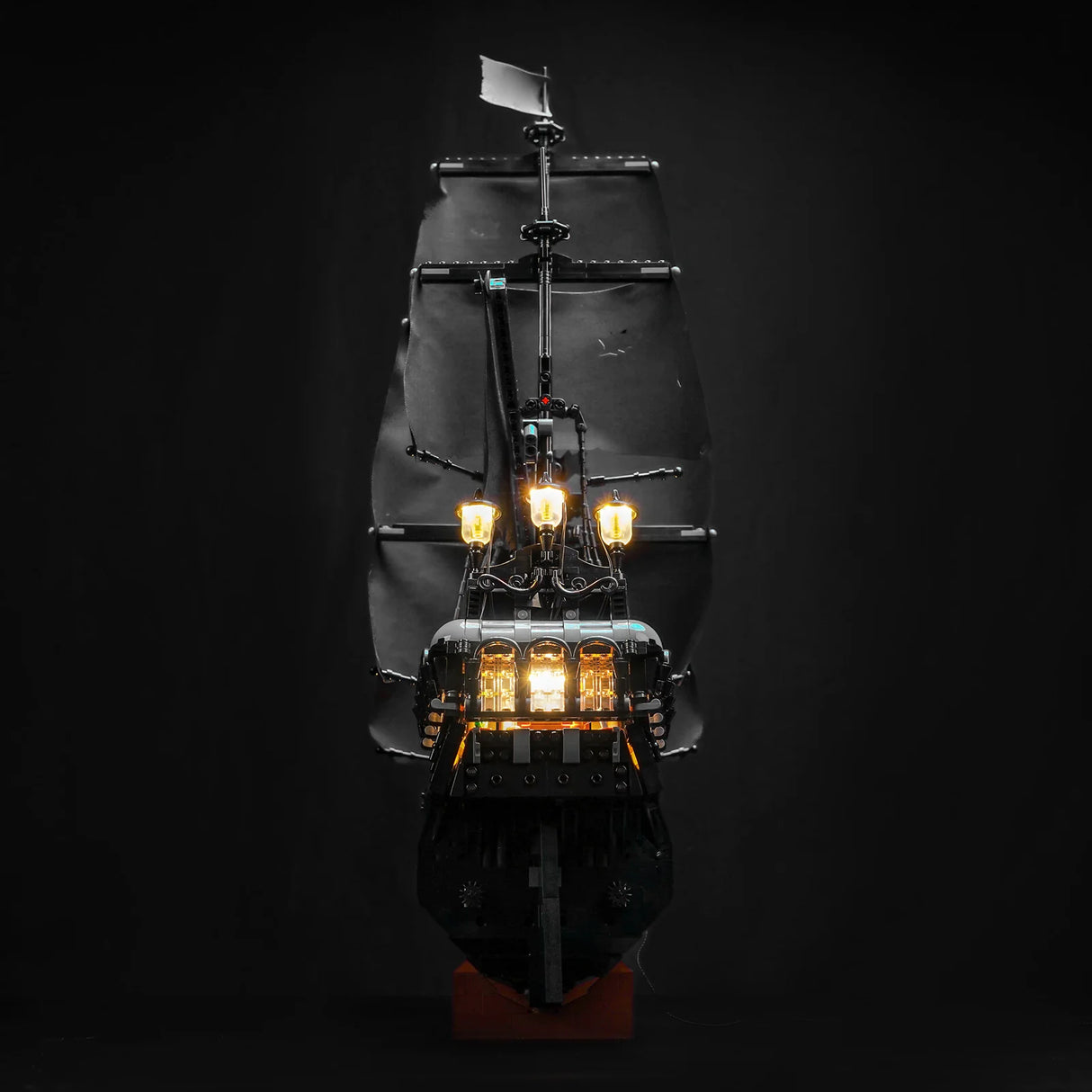 Ein schwarzes Piratenschiff mit leuchtenden Laternen und Segeln auf dunklem Hintergrund
