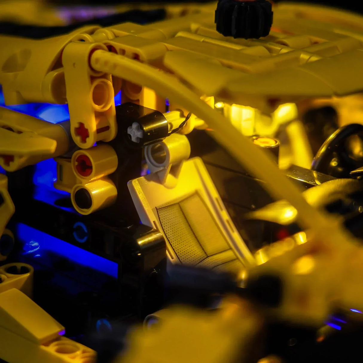 Nahaufnahme eines gelben Lego Technic Modells mit blauer und gelber Beleuchtung