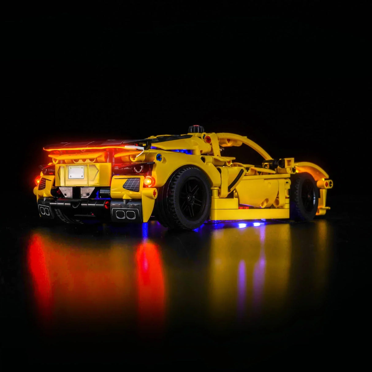 Gelbes Spielzeugauto mit roten und blauen Lichtern auf schwarzem Hintergrund