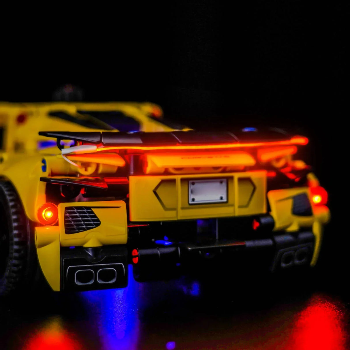 Gelbes Spielzeugauto mit leuchtenden roten und blauen Lichtern im Dunkeln