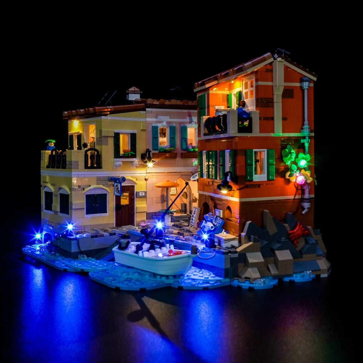 Beleuchtetes LEGO Fischerboot und Häuser bei Nacht