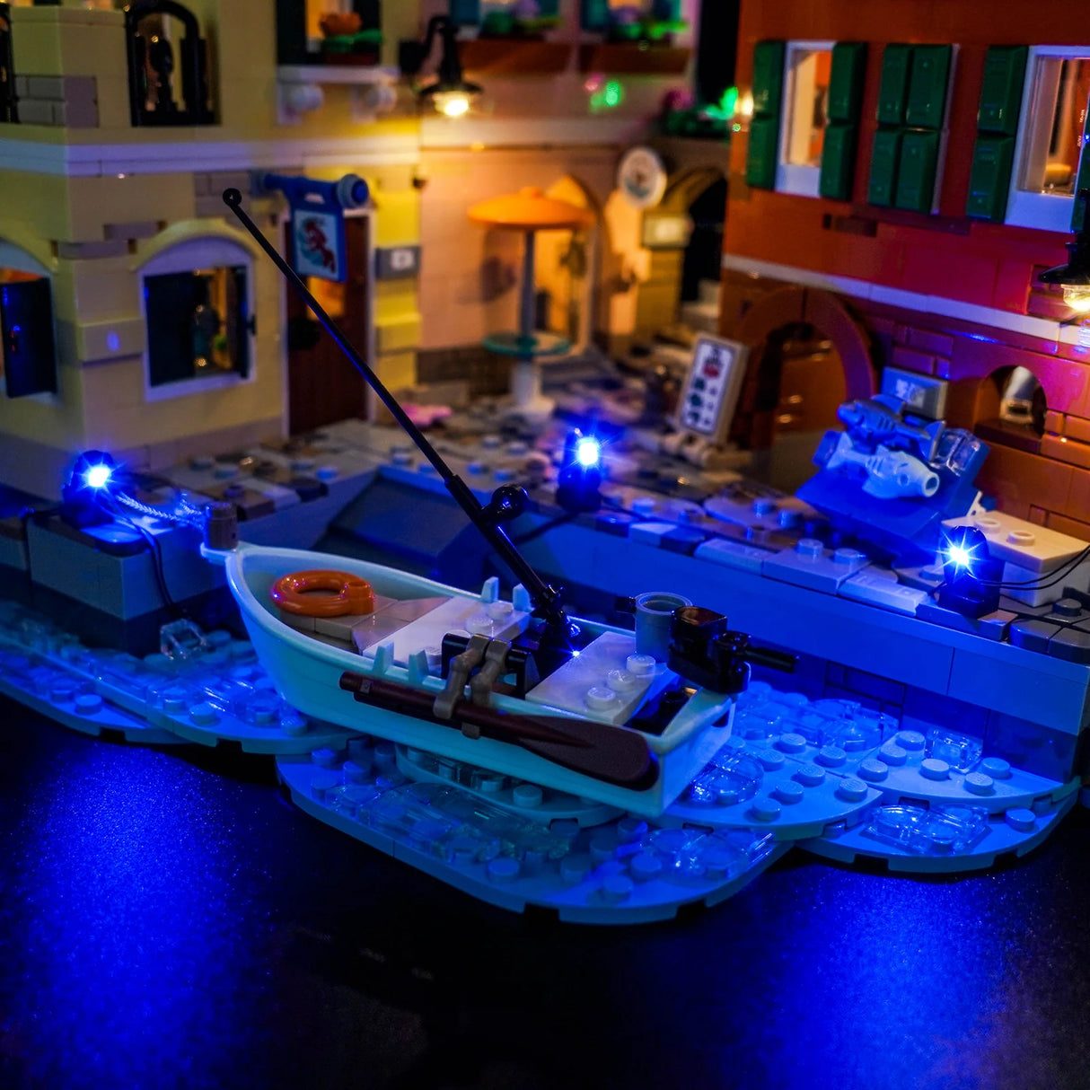 Beleuchtetes Lego-Fischerboot mit Angelrute und Rudern auf blauem Wasser
