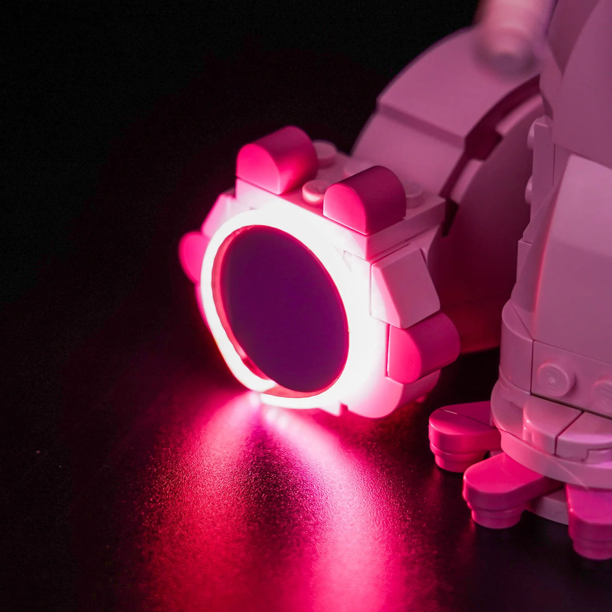 Nahaufnahme eines rosa und weißen Lego-Roboters mit leuchtenden rosa Lichtern