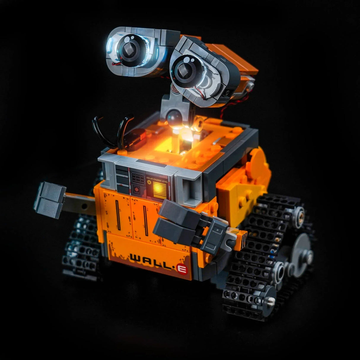 Lego Wall-E Roboter mit leuchtenden Augen und Solar-Ladeanzeige auf schwarzem Hintergrund