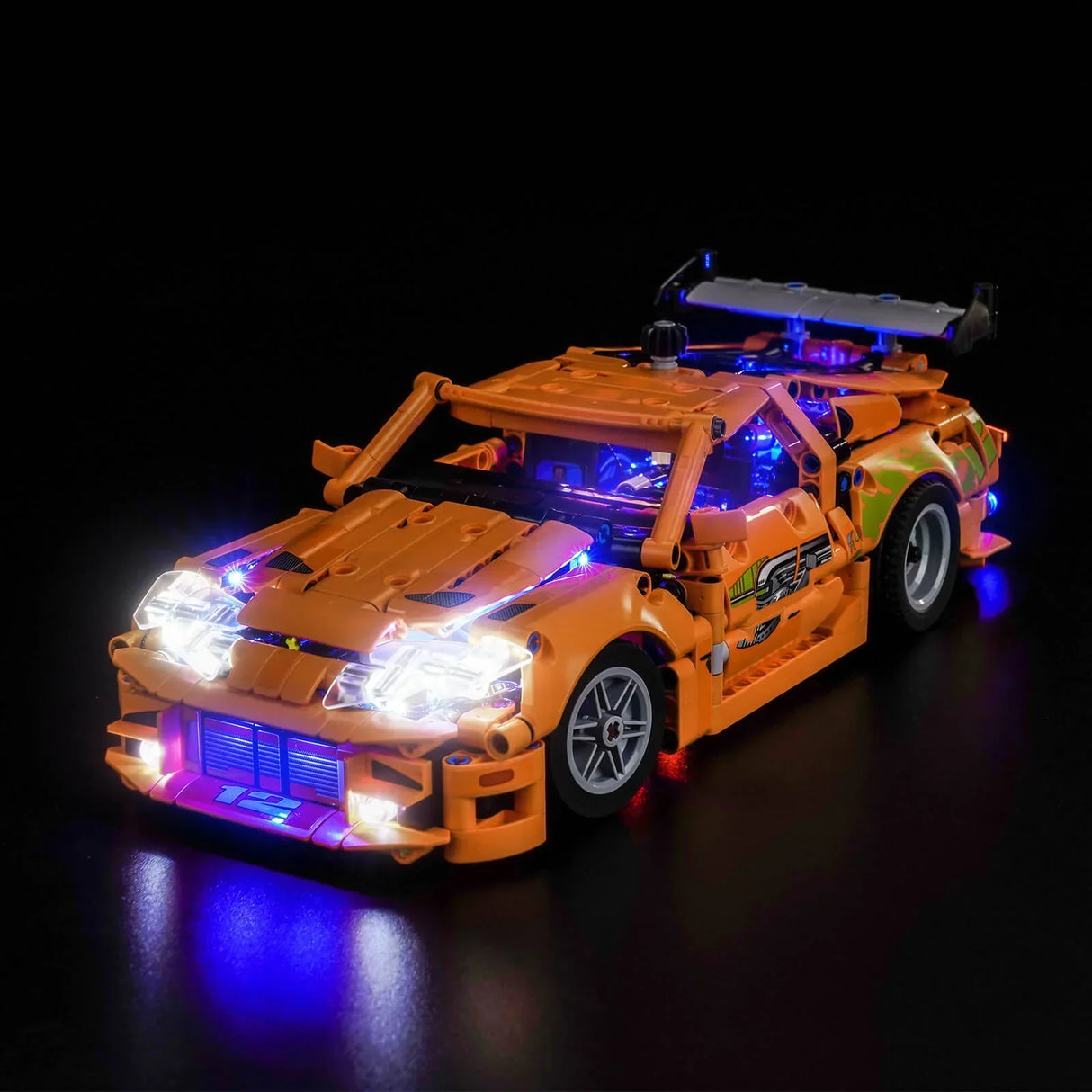 Orangefarbenes Spielzeugauto mit leuchtenden Scheinwerfern und blauen Unterbodenlichtern