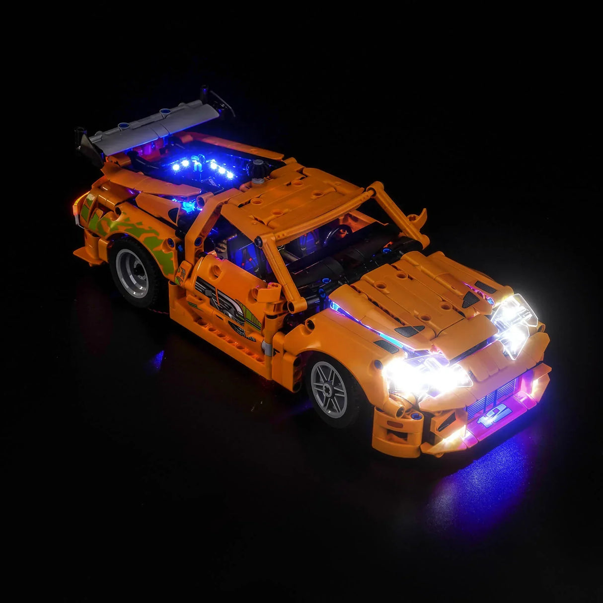 Orangefarbenes Spielzeugauto mit leuchtenden blauen und weißen Lichtern auf schwarzem Hintergrund