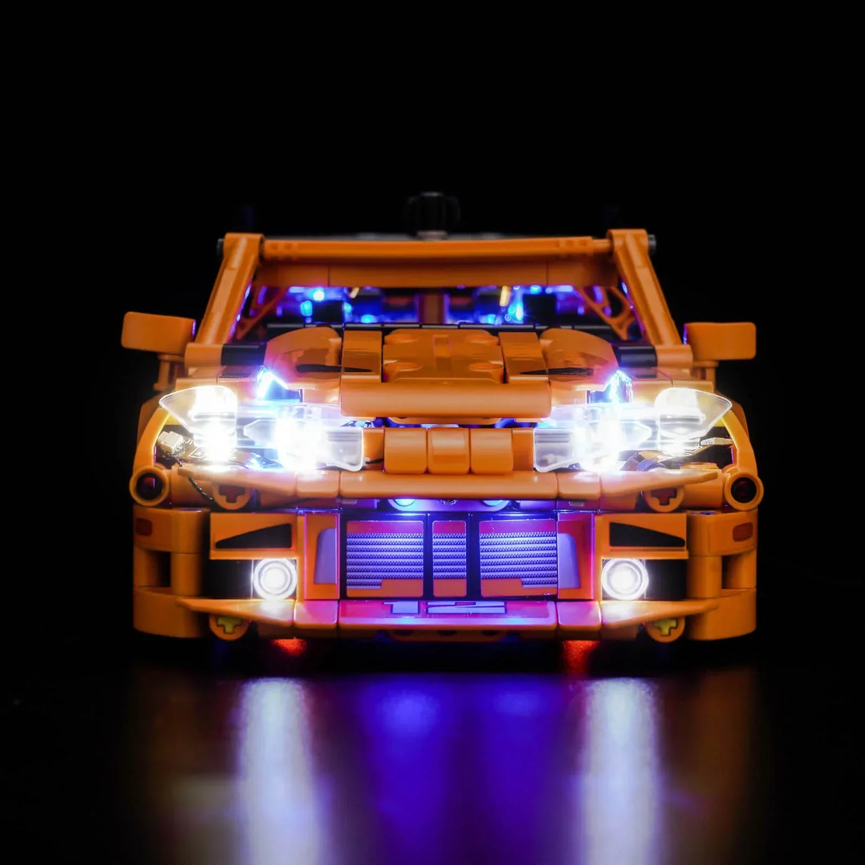 Orangefarbenes Spielzeugauto mit leuchtenden Scheinwerfern und blauer Innenbeleuchtung