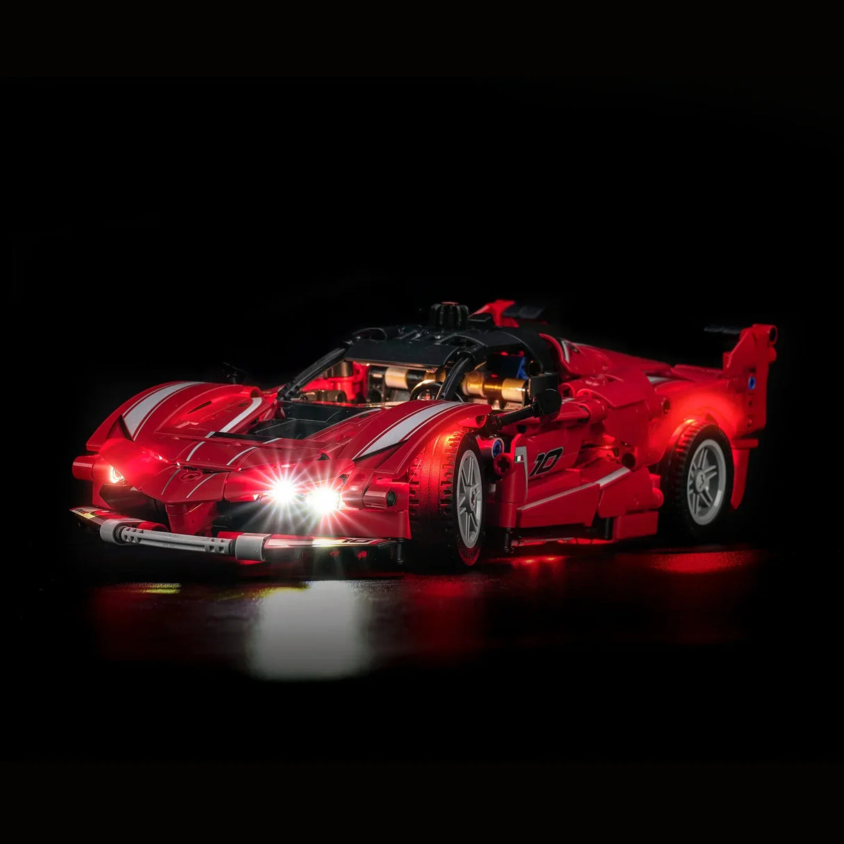 Rotes Spielzeugauto mit leuchtenden Scheinwerfern und Rücklichtern auf schwarzem Hintergrund