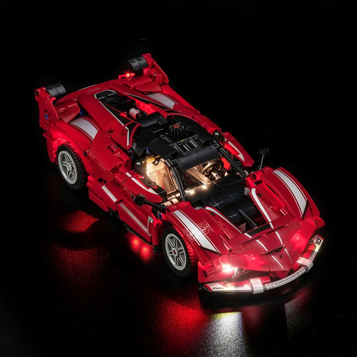 Rotes Spielzeugauto mit Lichtern auf schwarzem Hintergrund