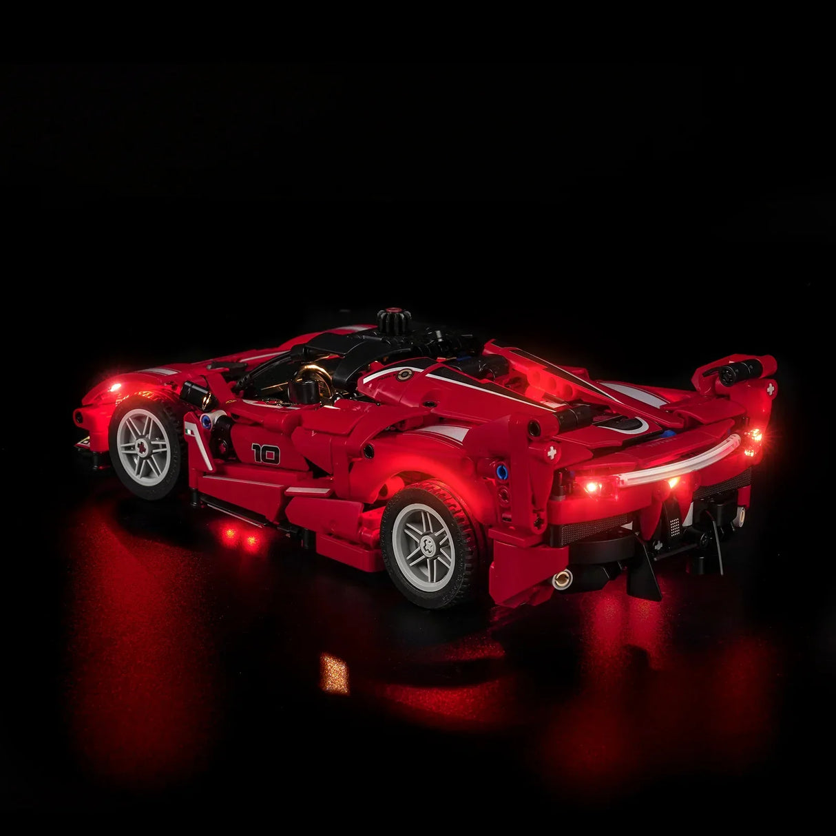 Rotes Spielzeugauto mit leuchtenden roten Lichtern auf schwarzem Hintergrund