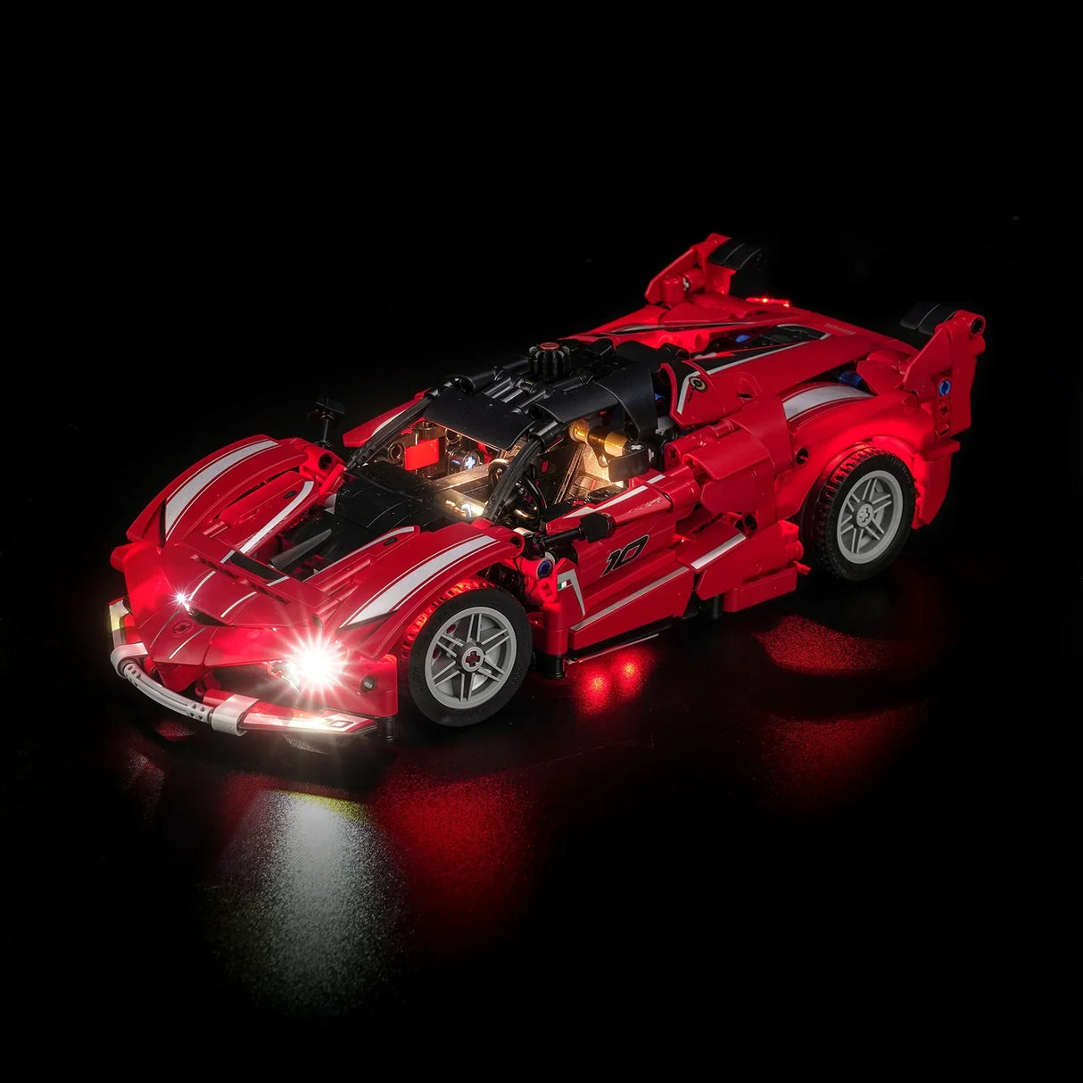 Rotes LEGO Technic Auto mit leuchtenden Scheinwerfern und Rücklichtern auf schwarzem Hintergrund