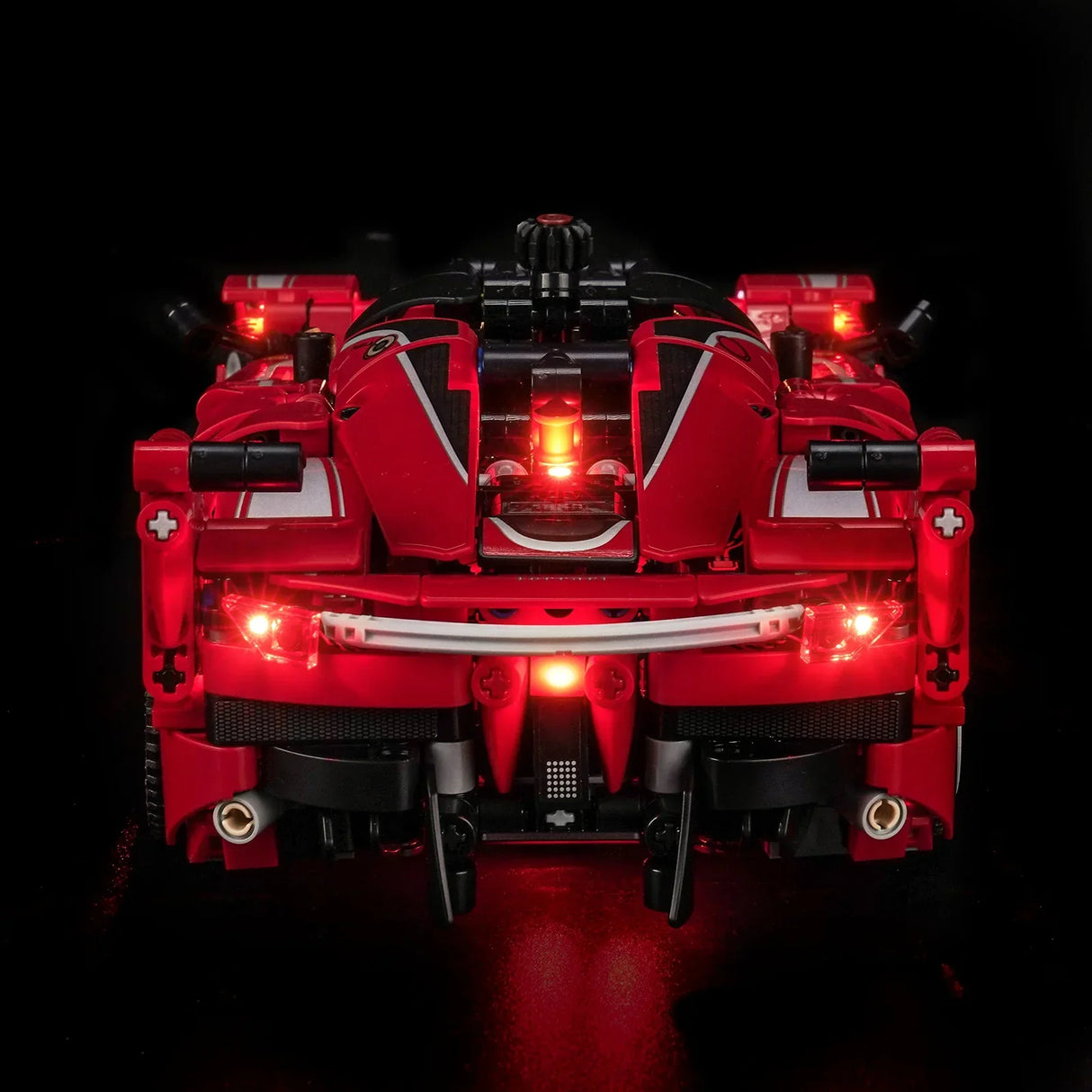 Rotes Spielzeugauto mit leuchtenden roten Lichtern auf schwarzem Hintergrund