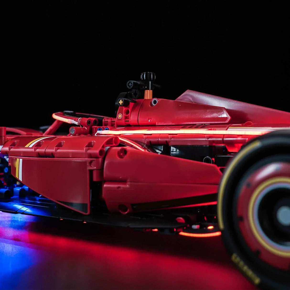 Roter Formel-1-Rennwagen mit leuchtenden roten und blauen Lichtern auf schwarzem Hintergrund