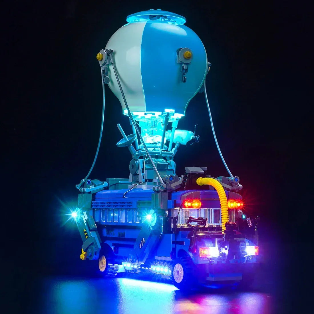 Beleuchtetes Lego Modell eines blauen Schlachtbusses mit Heißluftballon vor dunklem Hintergrund