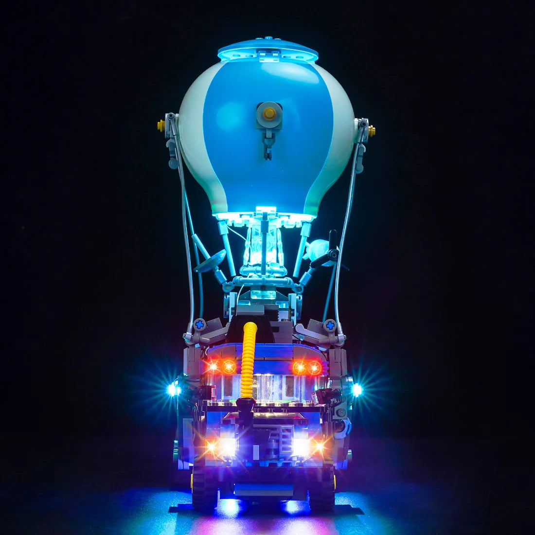 Beleuchtetes Lego Modell eines Fortnite Schlachtbusses mit Heißluftballon vor schwarzem Hintergrund