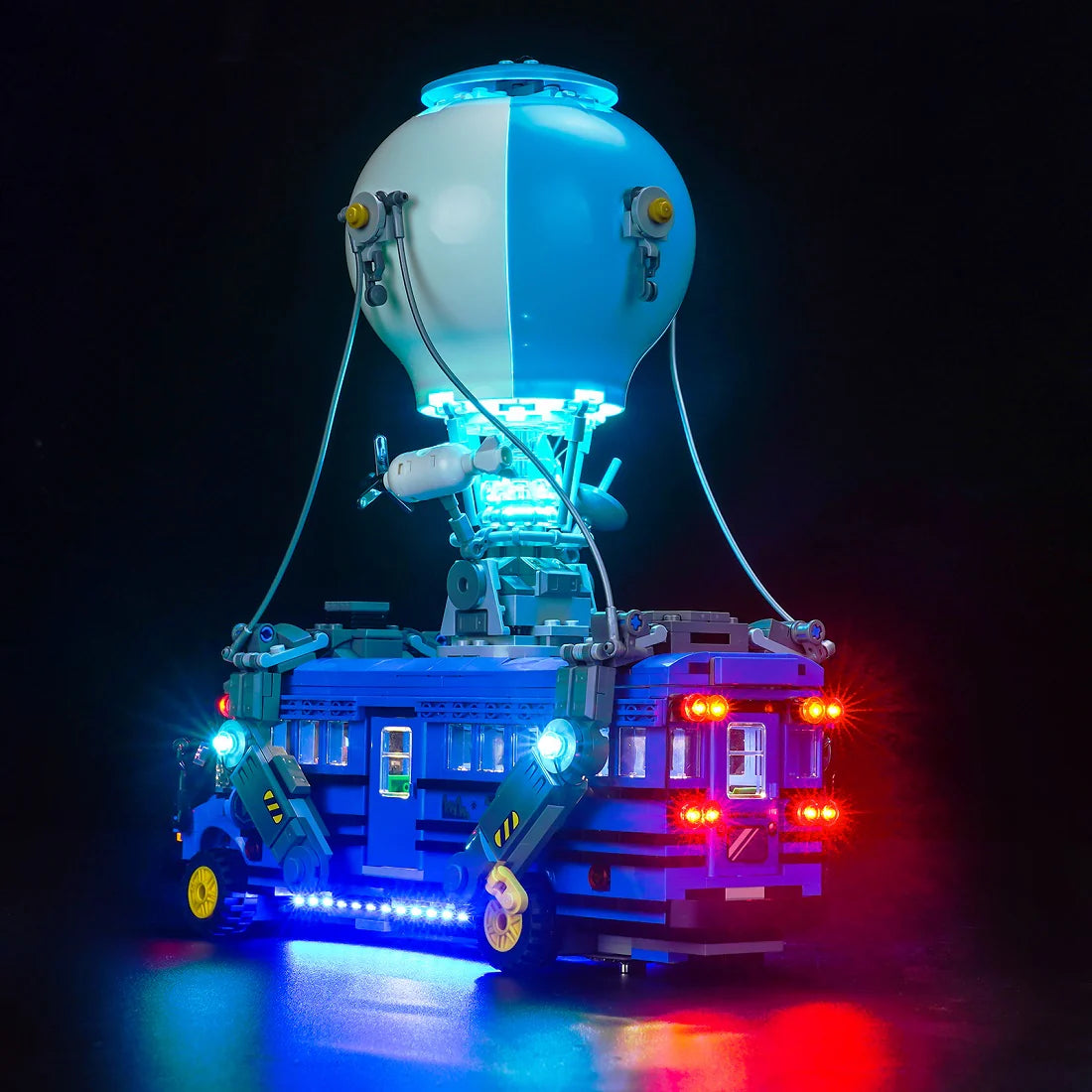 Beleuchtetes Lego Modell eines Fortnite Schlachtbusses mit Heißluftballon vor schwarzem Hintergrund