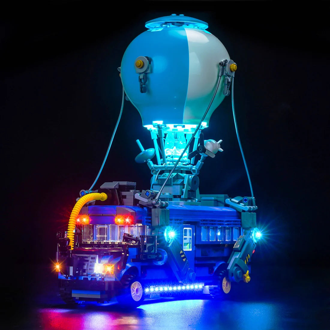 Beleuchtetes Modell eines blauen Busses mit Heißluftballon vor schwarzem Hintergrund