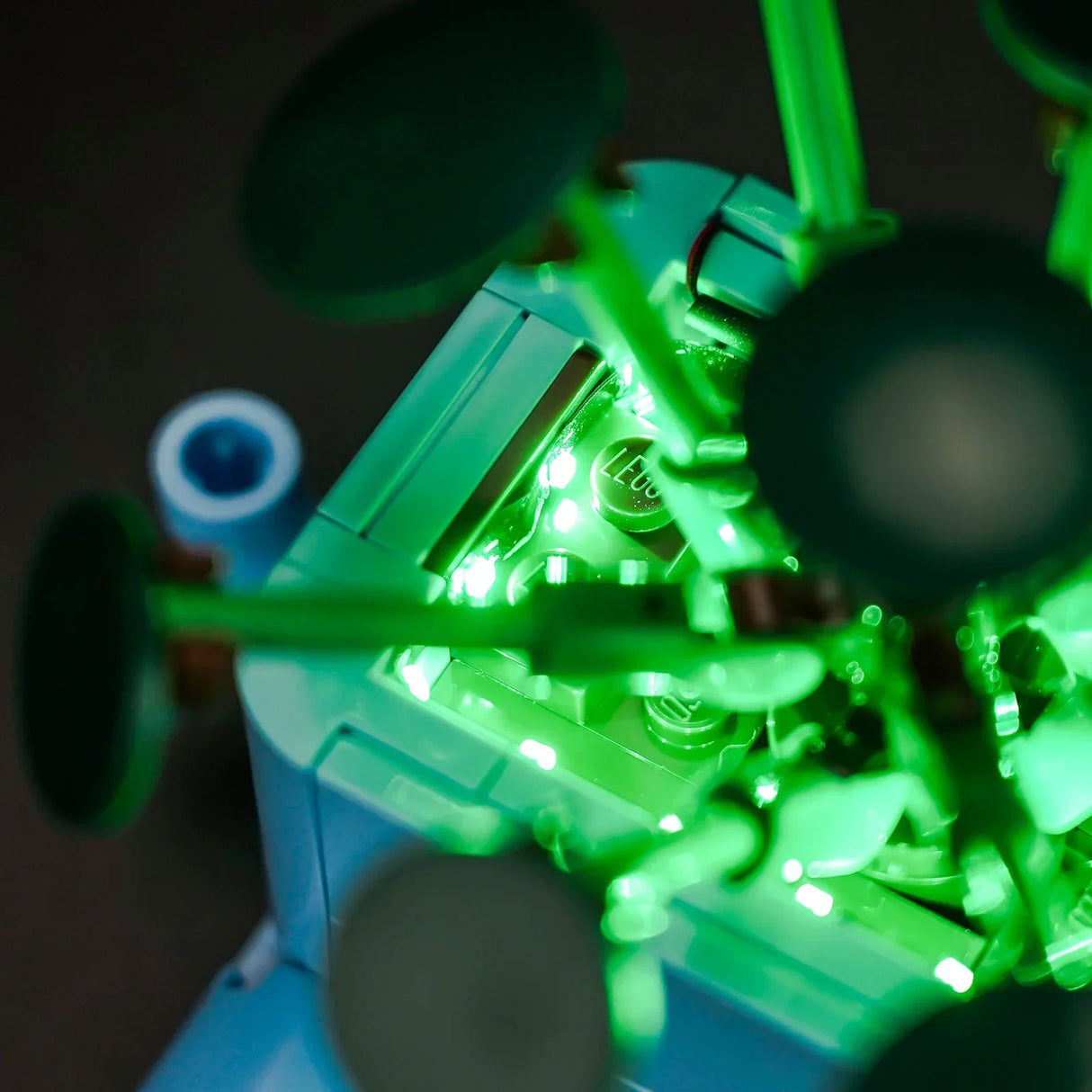 Nahaufnahme eines LEGO-Modells mit leuchtend grünen Lichtern und dem LEGO-Logo