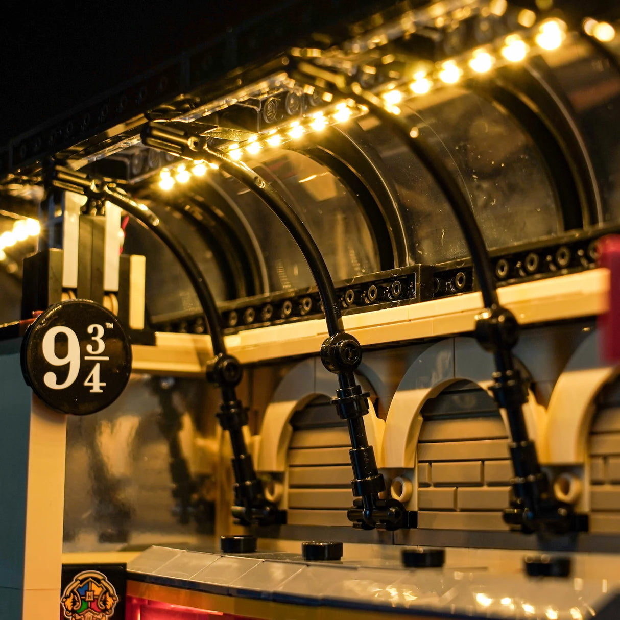 Nahaufnahme des beleuchteten Lego Harry Potter Bahnhofs mit dem Schild Gleis 9 3/4